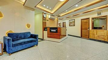 A reception area with a blue sofa, a reception desk labeled 'Townhouse Company Serviced,' and a clock on the wall.