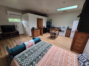 A modern apartment with a living area, a dining table, and a kitchen. - Cozy cottage close to skiing, hiking, and not far from downtown! (Murray)