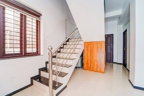 A staircase with metal railings and a wooden door in a hallway.