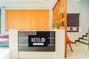 A hotel reception desk with a sign indicating it is company-serviced.