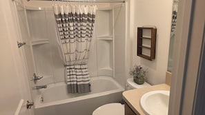 Een badkamer met een douche, toilet en wastafel.