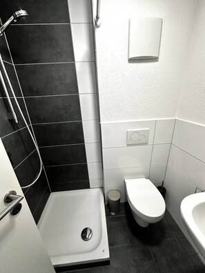 A modern bathroom with a shower, toilet, and bidet. - STAY | Smart Studio, Parkplatz, Bodensee (Friedrichshafen)