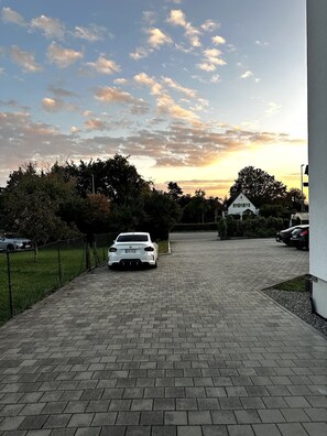 Un camí pavimentat condueix a una casa blanca amb un sender de maó.