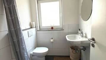 Ein kleines Badezimmer mit Toilette, Waschbecken und Duschbereich.