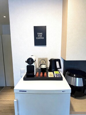 A coffee station with a coffee maker, cups, and a sign that says 'TIME FOR COFFEE'. - STAY | Comfort Apartment am Bodensee (Friedrichshafen)