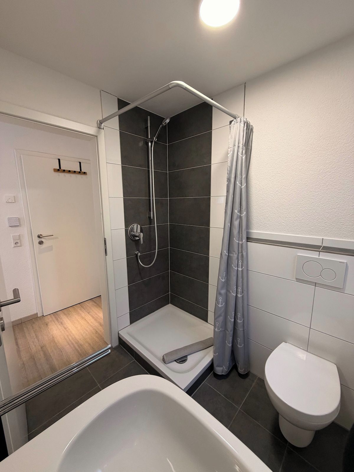 Ein Badezimmer mit Dusche, Toilette und Badewanne.