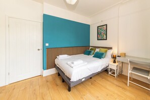 A bedroom with a bed, bedside table, and a small desk with a lamp. - Private Studio Near Shops & River Thames - Pass the Keys (Reading)