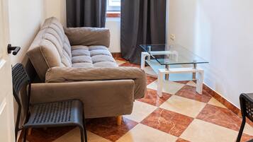 A compact living space with a sofa, a small table, and a chair.