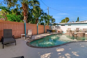 A backyard with a swimming pool, a wooden fence, and outdoor furniture. - Old-Florida Resort, Steps to Beach & Village, Heated Pool (Siesta Key)