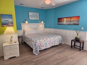 A bedroom with a bed, bedside table, lamp, and wall art. - Old-Fl Retreat, Walk to Beach & Village, Heated Pool (Siesta Key)