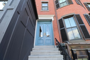 A building with a blue door, numbered 627, and a black awning. - Good Hotels Boston (Boston)