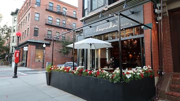 A restaurant with outdoor seating, a brick facade, and a sign reading 'Desnud.'