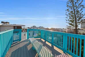 A wooden deck with a turquoise railing, overlooking a residential area with houses and a clear sky. - Steps to the Sand, Walk to Village, Private Deck (Siesta Key)