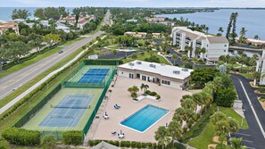 A residential area with a tennis court, a swimming pool, and a road. - Heated Pool, Bayfront, Fitness Center, Tennis (Longboat Key)