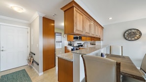 The kitchen opens toward the dining and living areas, giving the home a comfortable, connected layout. Granite counters and warm wood cabinetry complement the relaxed coastal interiors. - Heated Pool, Bayfront, Fitness Center, Tennis (Longboat Key)