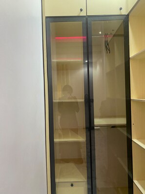 Una habitación con un aparador de vidrio y varias repisas.