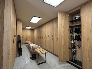 A locker room with wooden lockers, a bench, and a rack for shoes. - Reflet Des Cimes Loan Lodge (Les Belleville)