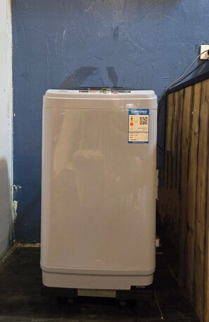 A white refrigerator in a corner with a blue wall and a wooden fence. - OH Trendy homes Hoan Kiem LPH  - city center - 2 beds (Hoan Kiem)