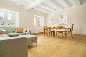 A spacious living room with a sofa, dining table, and chairs. - New Listing (Nieheim)