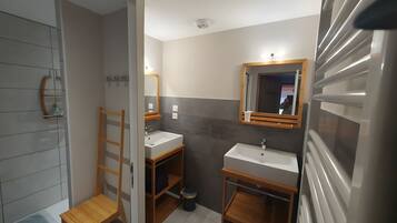 A bathroom with a shower, a sink, and a mirror.