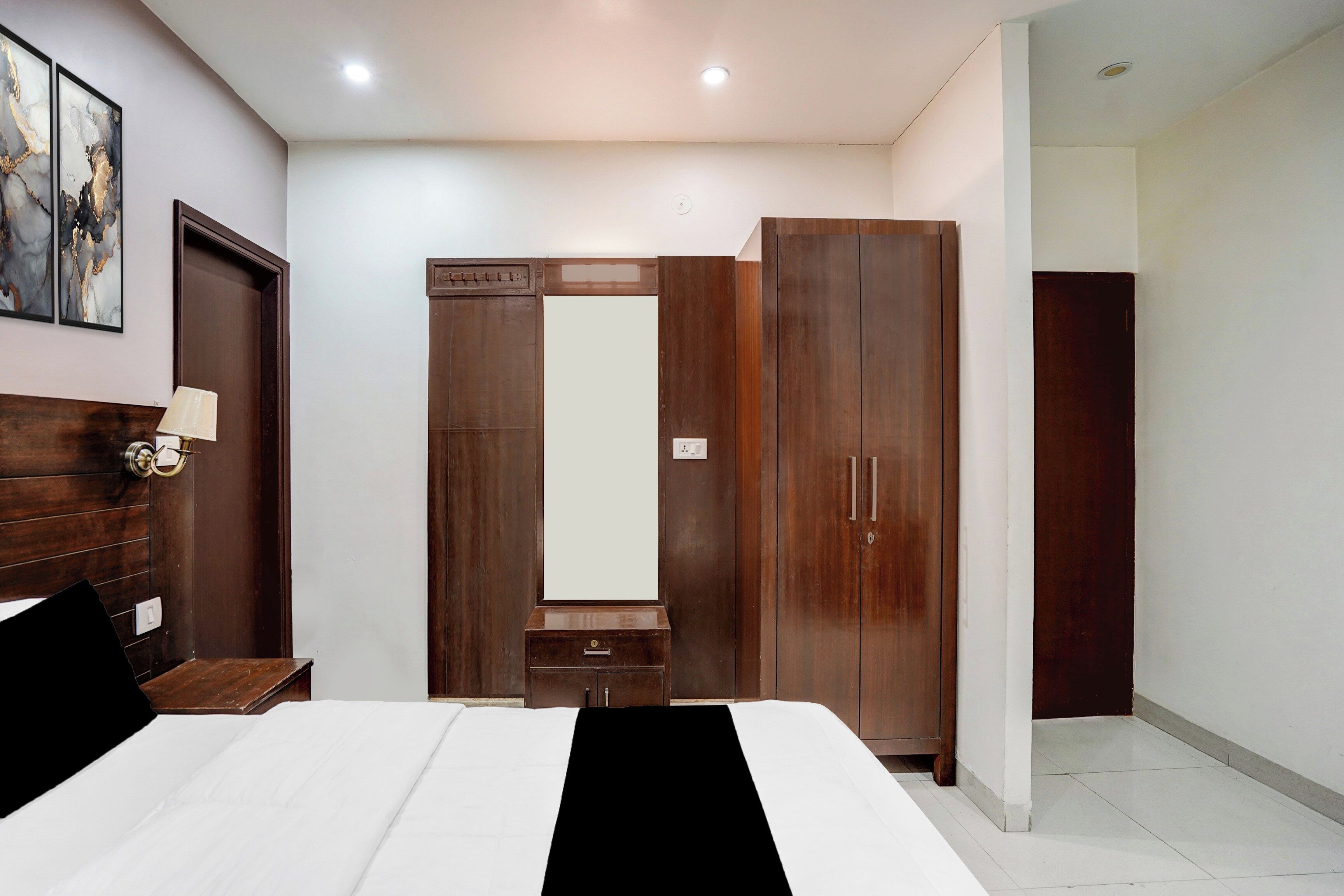 Une chambre à coucher avec un lit, une table de chevet, une armoire et un miroir.