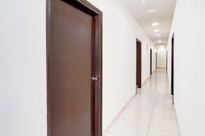 A corridor with doors on both sides, leading to rooms.