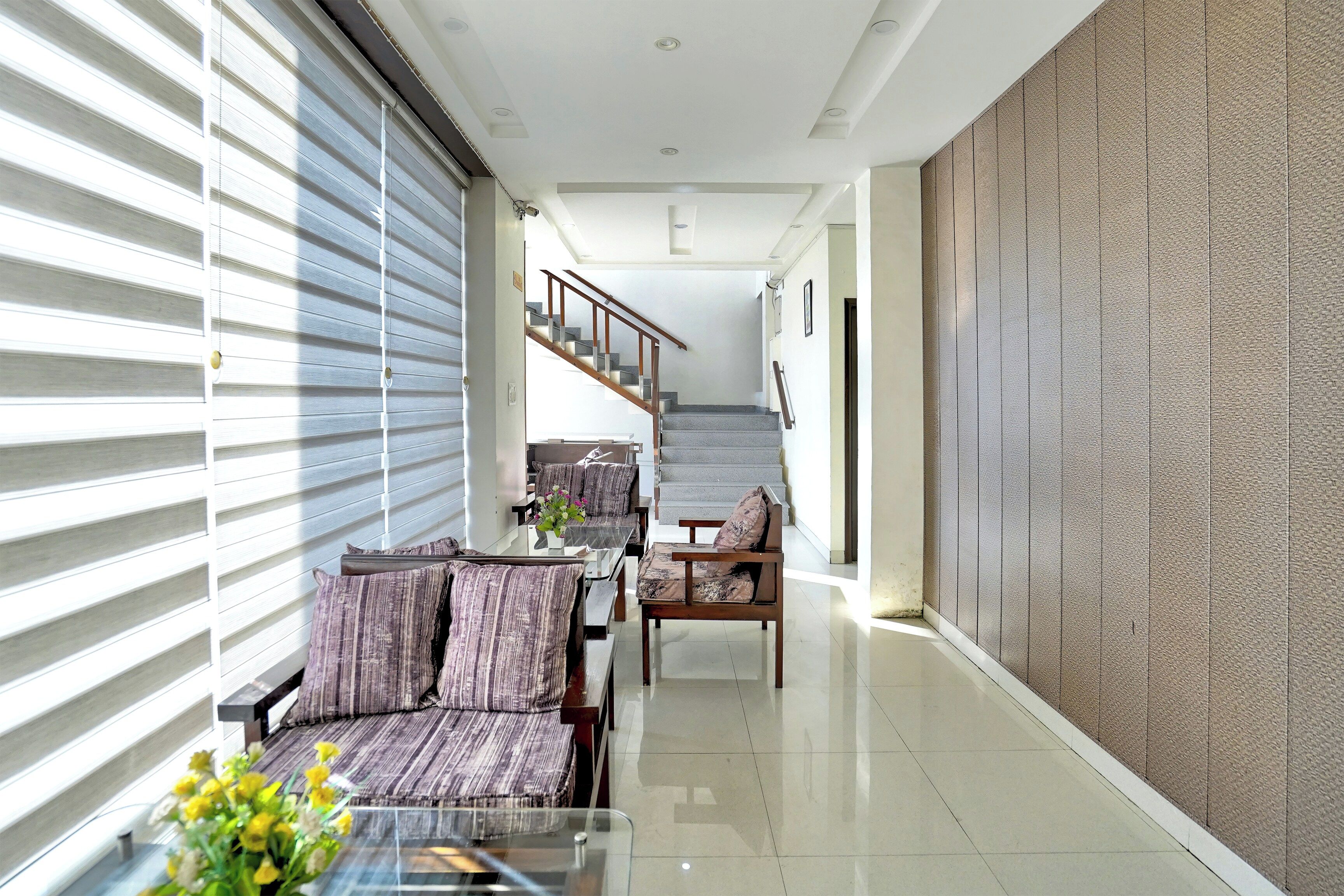 A modern interior with a dining area, a staircase, and a textured wall.