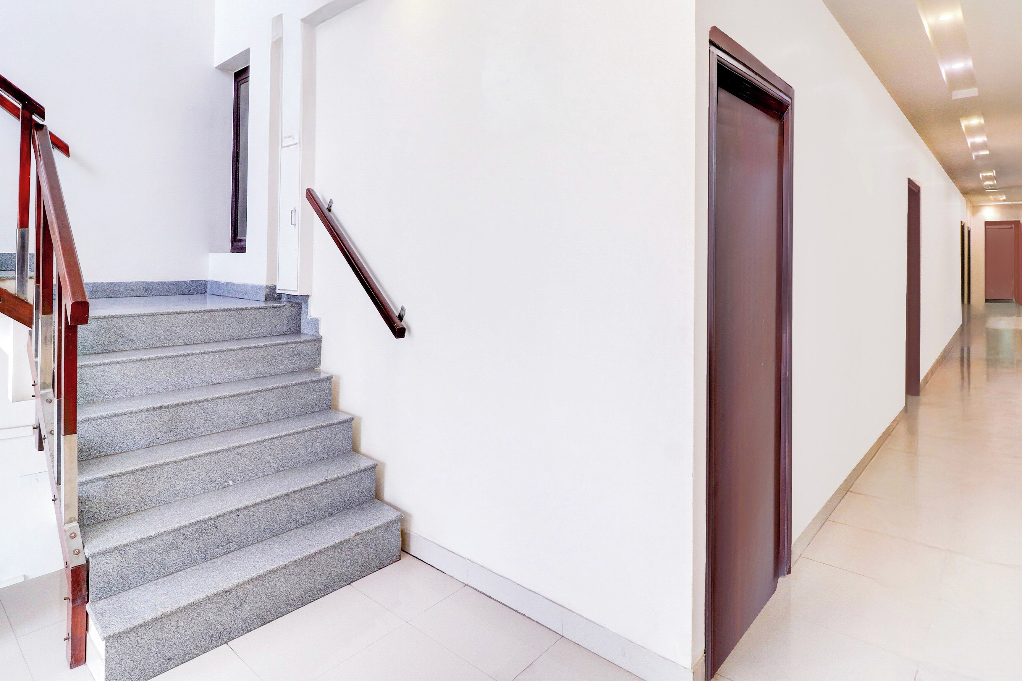A modern interior with a staircase, a door, and a hallway.