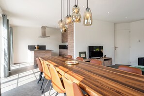 A modern kitchen with a wooden countertop, a built-in oven, and a stainless steel range hood. - New Listing (Cadzand)