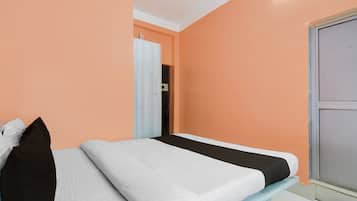 A single bed in a room with peach walls and a white ceiling.