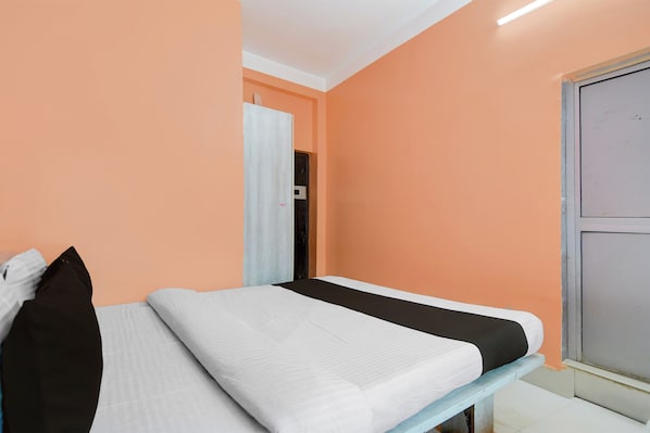 A single bed in a room with peach walls and a white ceiling. - Hotel O Tarapith Temple (Tarapith)
