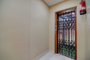 A room with a door that has a metal security gate. - Hotel O Tarapith Temple (Tarapith)