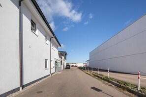 A narrow alleyway between buildings with a clear sky above.