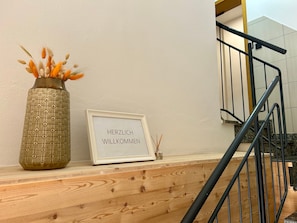 A wooden bench with a framed welcome sign and a decorative vase with dried flowers. - Apartment 'Nr. 3' with Wi-Fi (Jettingen-Scheppach)