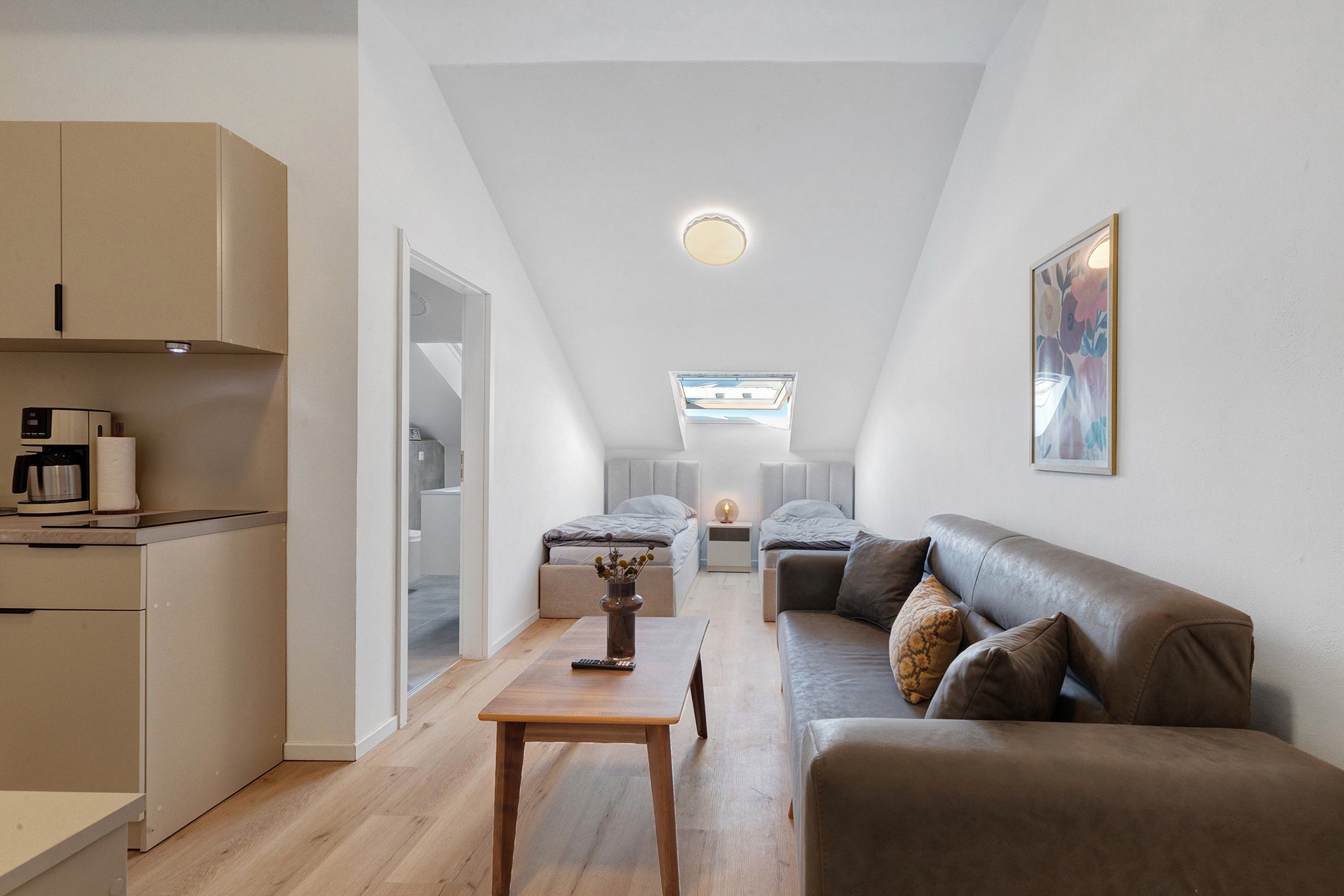 Ein gemütlicher Wohnbereich mit Küchenzeile, Essbereich und einer Sitzecke mit Sofa und Tisch.