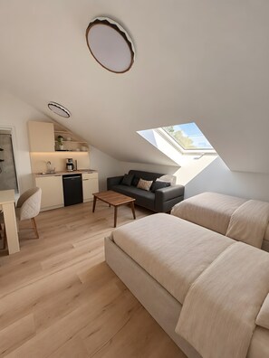 Ein modernes Loft mit Küche, einer Couch, einem Essbereich und einem Oberlicht.