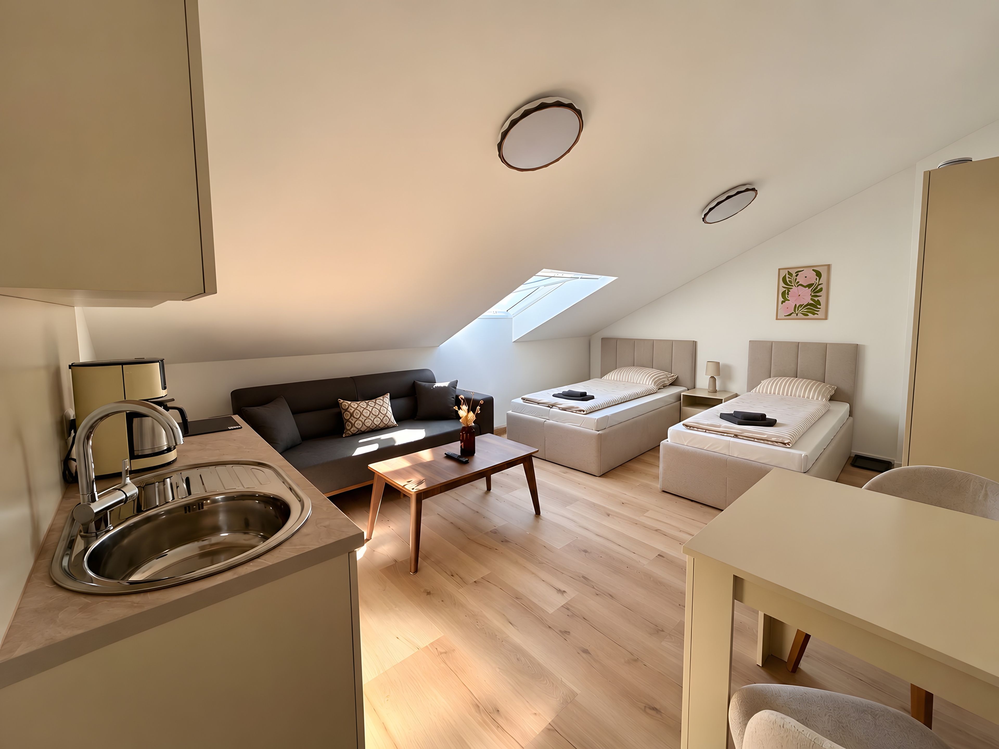 Um espaço compacto com cozinha americana, sofá, cama e área de refeições.