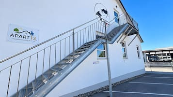 Un immeuble avec une enseigne indiquant « APART 13 » et un escalier menant à un étage supérieur.