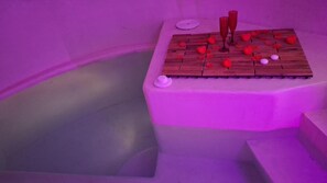 Una habitación con una plataforma de madera, una mesita y un par de gafas.