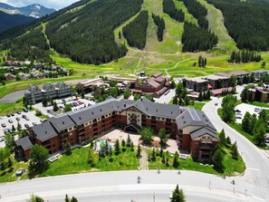 A large hotel with multiple buildings, a parking lot, and a view of a mountainous landscape. - Copper Springs Getaway with Great Ski Access (Copper Mountain)