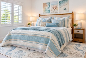 A bedroom with a bed, bedside tables, and artwork on the wall. - "Beach, Please!" Ocean View Townhome.  Three bed, three bath.  Sleeps 10. (Bimini Bay)