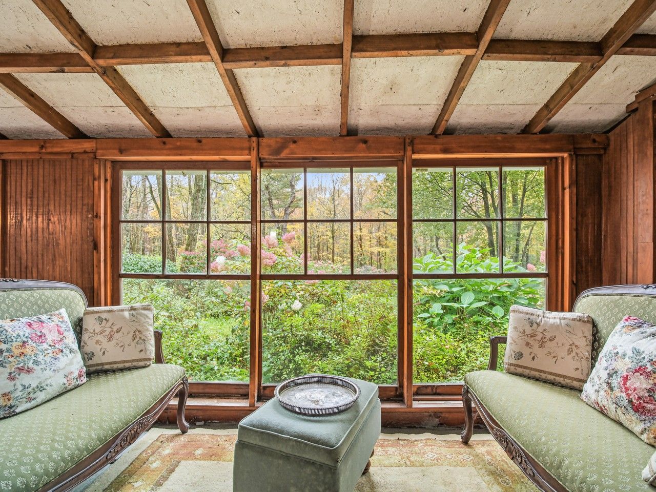 A room with a large window, two sofas, and a small table.
