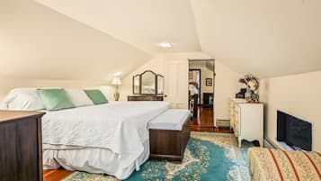 Ein Schlafzimmer mit Bett, Kommode, Fernseher und Spiegel.