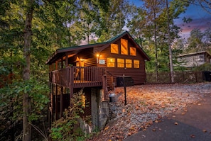 A wooden cabin with a balcony, surrounded by trees and a gravel path. - Hot Tub-Fireplace-Private-Honeymoon-Hiking-Relax (Sevierville)