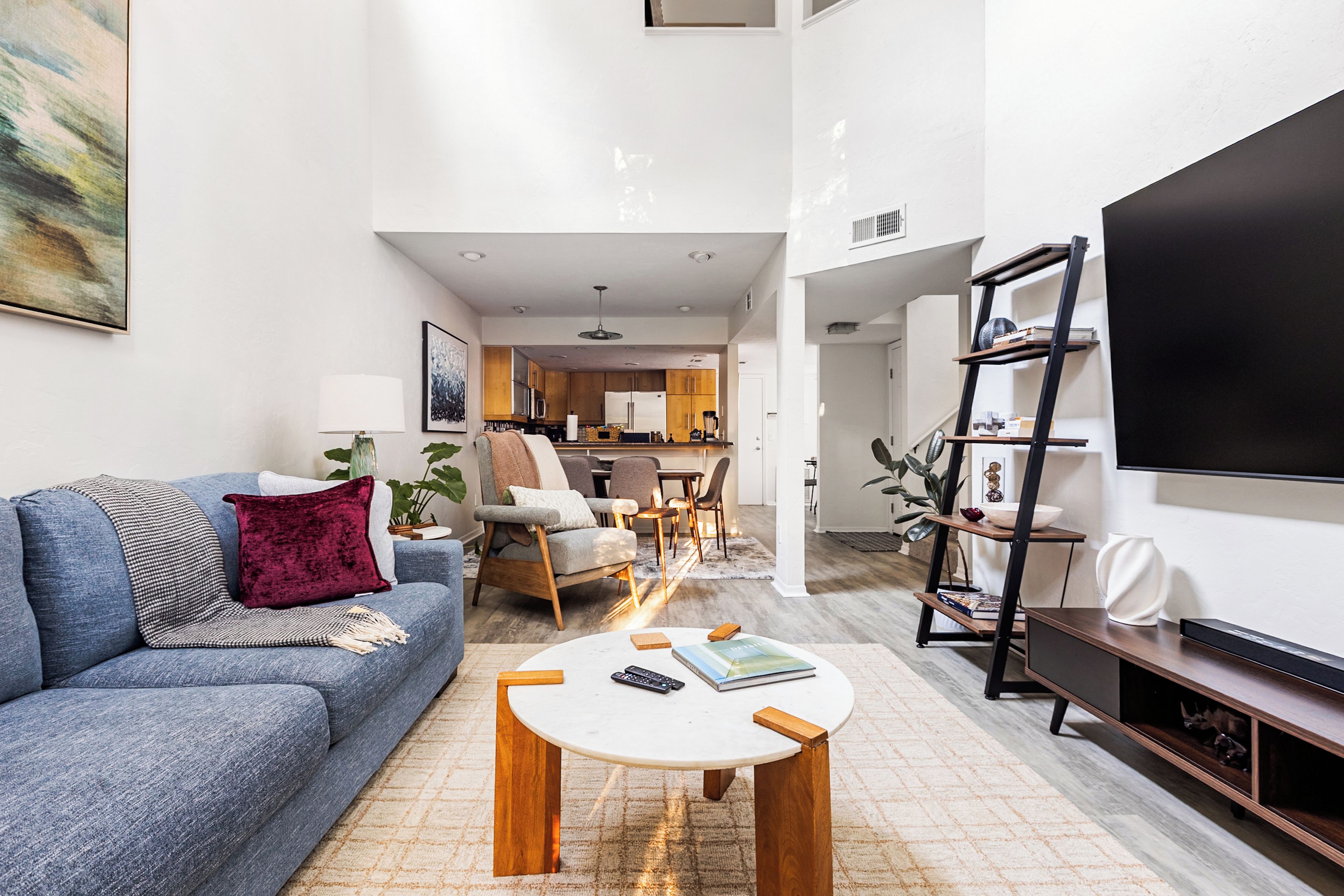 A modern living room with a sofa, coffee table, and a TV on a stand.