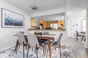A modern kitchen with wooden cabinets, a built-in oven, and a refrigerator. - Gator Glam (Gainesville)