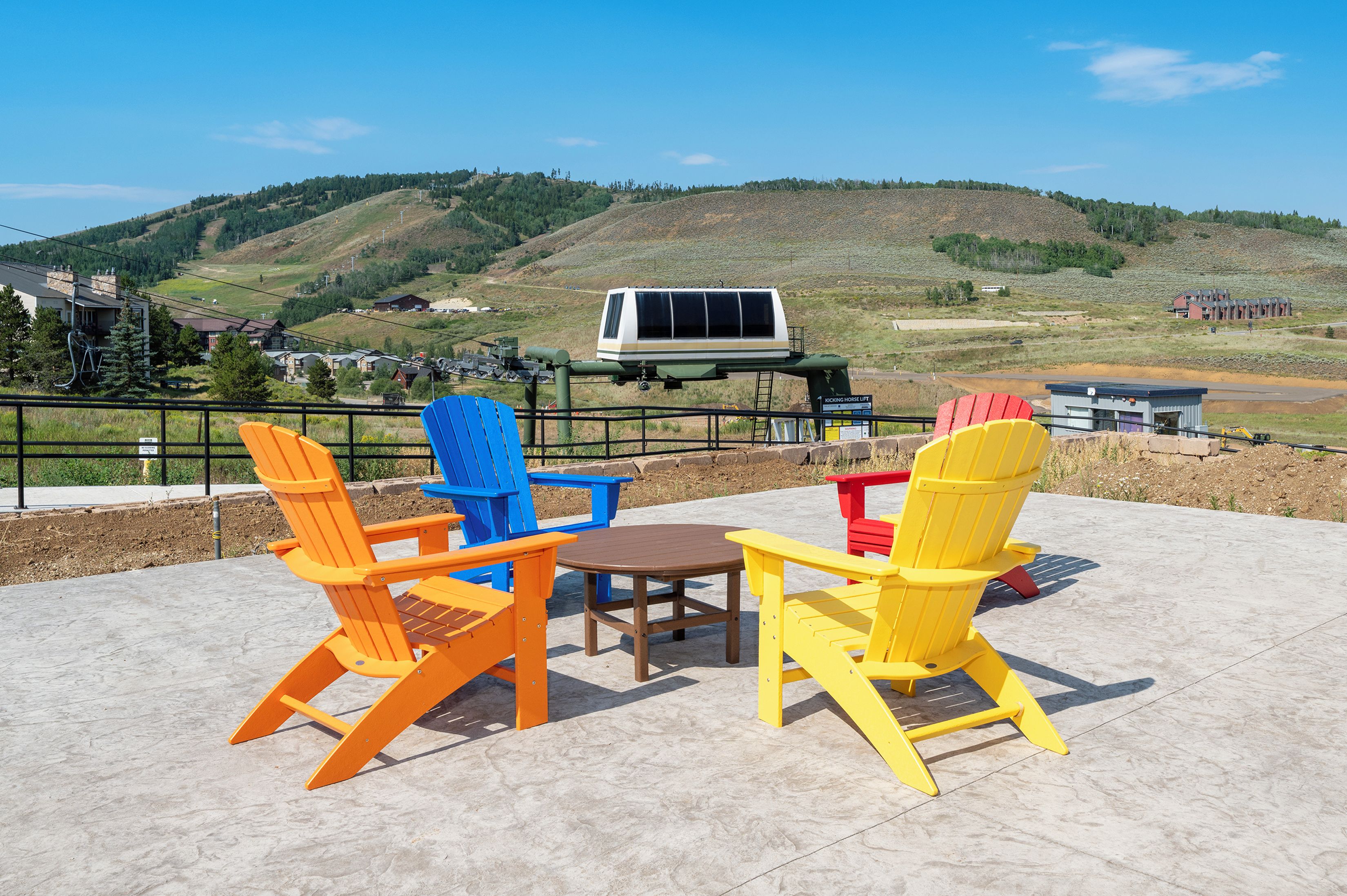 Outdoor seating with a view of a hilly landscape and a ski lift in the background.