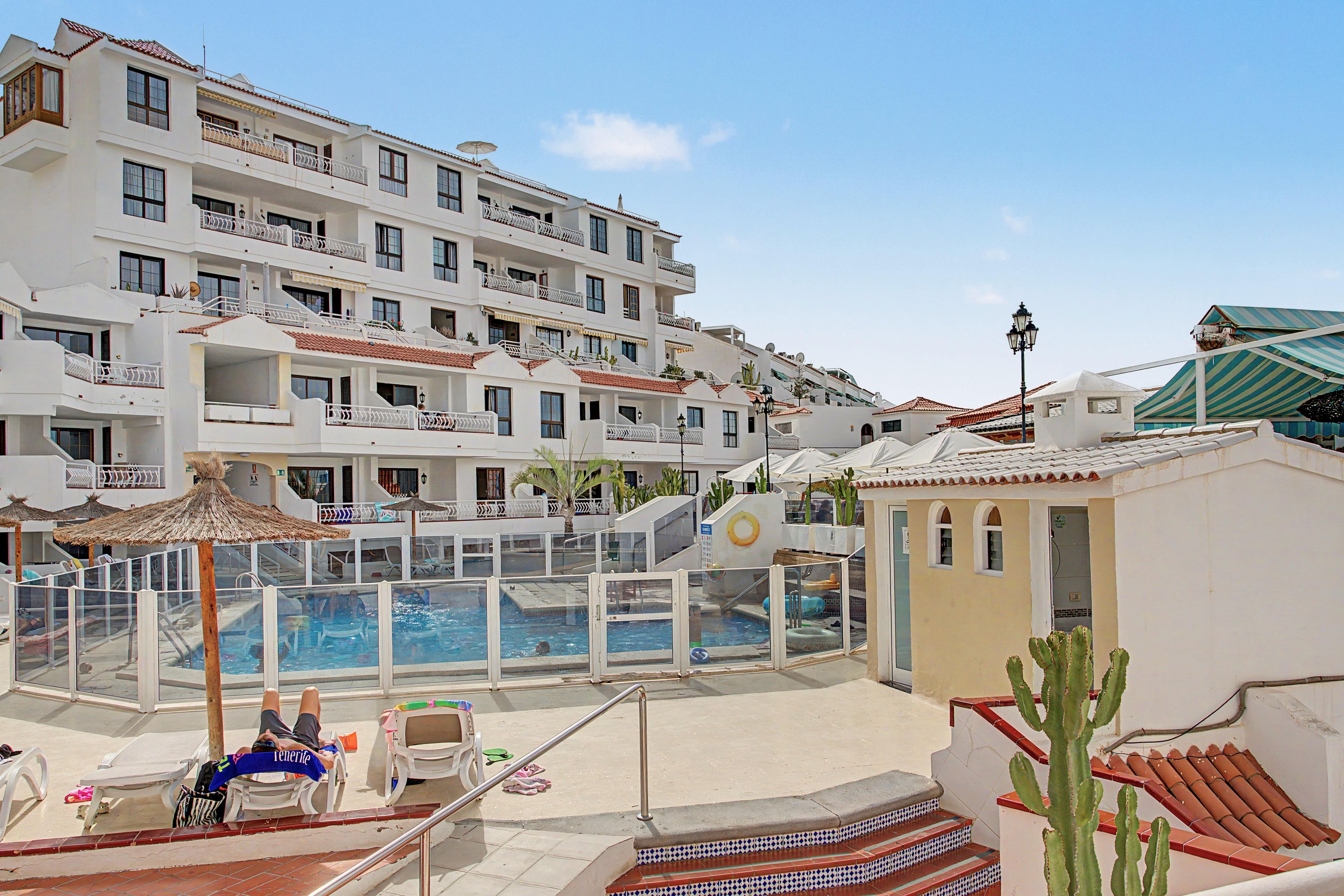 Un hôtel doté d’une piscine, de plusieurs balcons et offrant une vue sur un ciel dégagé.