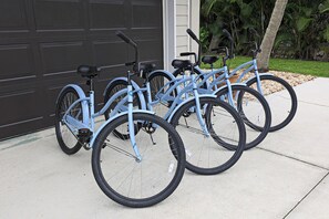 A row of bicycles parked outside a building with a garage door. - Cozy 2-bedroom house near downtown Bonita Springs (Bonita Springs)