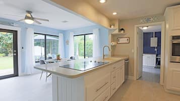 A modern kitchen with a central island, a dining area with a view, and a separate dining room.